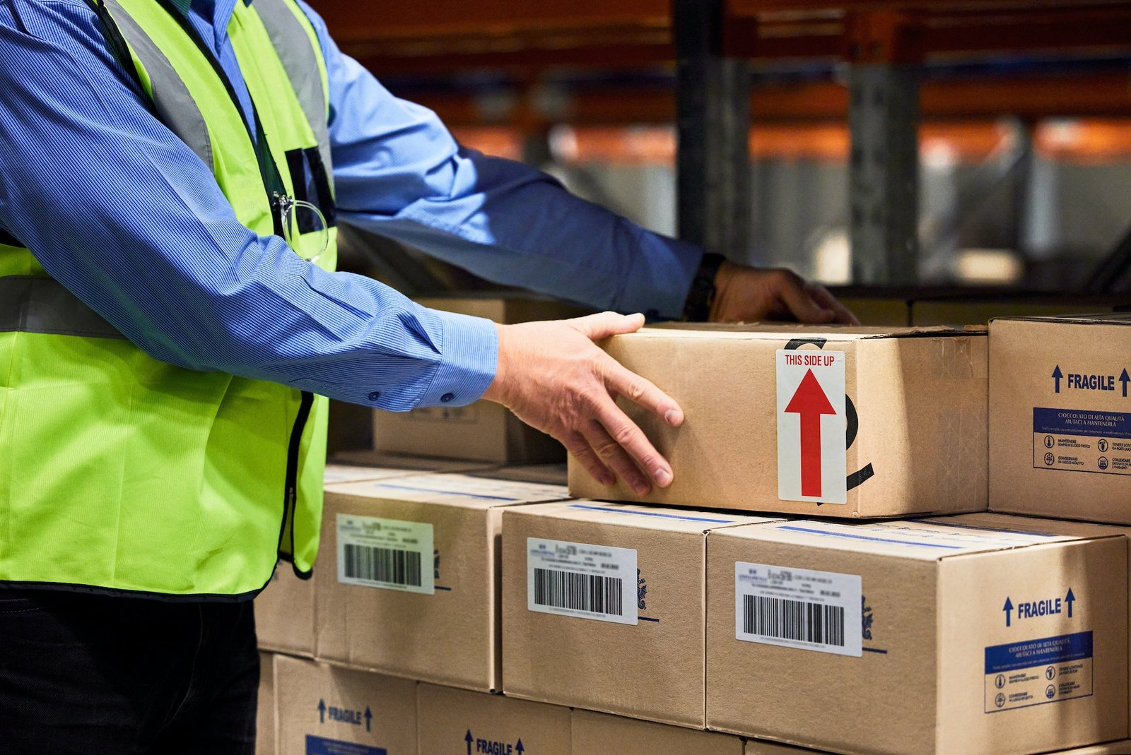 Shot of a unrecognizable man packing boxes in a warehouse